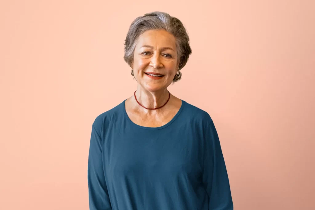 senior woman smiling brightly with blue top utc